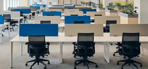 Modern open-plan office space featuring clean workstations, ergonomic chairs, and sanitized carpets provided by professional office cleaning services in Wilmington, NC.