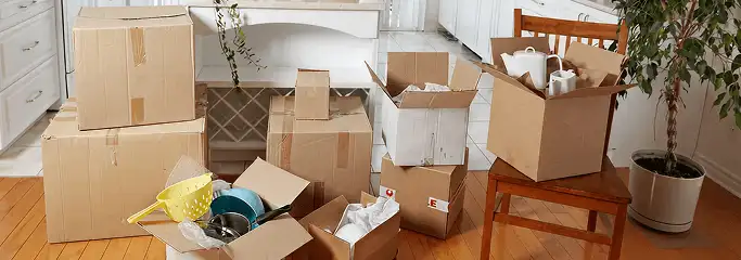 Packed moving boxes and household items in a kitchen before move-out or move-in cleaning, Wilmington, NC.